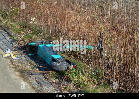 Elektroroller verlassen. Ein im Gras liegender Elektroroller. Stockfoto