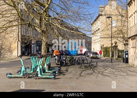 Tier E-Scooter, Fahrräder und Busse in Westgate Buildings, Bath City Centre, Somerset, England, Großbritannien Stockfoto