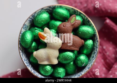 Schokoladenbonbons und Narzissen. Frühlingsferien Konzept. Stockfoto