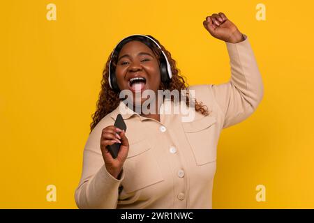 Lustige positive, übergewichtige schwarze Frau, die Lieder singt Stockfoto