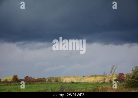 Entferntes weißes Bauernhaus, das sich in Wasser auf der Einfahrt vor dem Sturm spiegelt Stockfoto