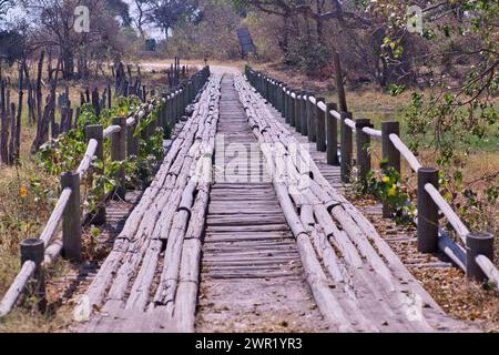 Eine wackelige Holzbrücke über einem großen Gewässer in Afrika, an der Kraftfahrzeuge vorbeifahren können. Stockfoto