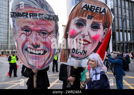 Ein Demonstrant, der sich für einen Waffenstillstand in Palästina einsetzt und Anti-Kier Starmer und Angela Rayner-Plakate während eines marsches gegen die anhaltenden militärischen Offensive hält Stockfoto