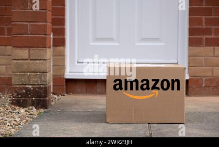 Exeter, UK-10. März 2024: Ein Versandkarton von Amazon vor einer Haustür. Amazon gilt als eines der fünf großen amerikanischen Technologieunternehmen Stockfoto