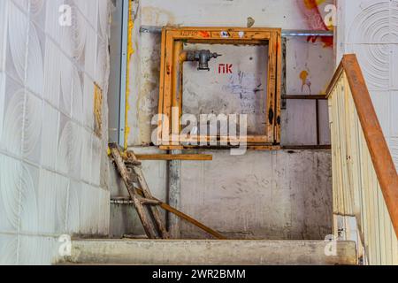 Feuerwehrschrank, alter Schrank in schlechtem Zustand. Brandschutzkonzept, Feuerlöscher und Löschschlauchtrommel im Korridor öffentlicher Gebäude. Charkiv Ukraine 05-05-202 Stockfoto