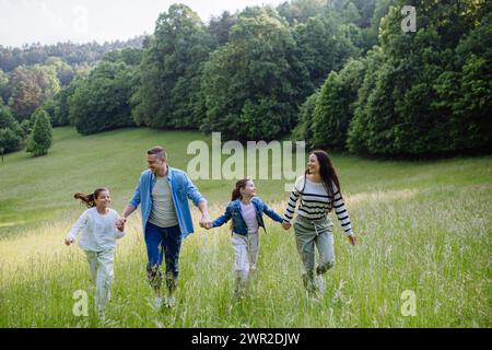 Die Familie läuft durch den Wald, geht durch die Wiese. Pilze sammeln, Kräuter sammeln, Blumen im Korb sammeln, Futter sammeln. Konzept des familiären ökologischen Hobbys in Stockfoto