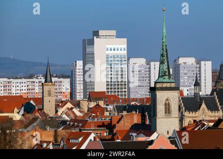 Blick auf die Plattenbauten am 09.03.2024 in Erfurt. Die Wohnbloecke, die in der DDR-Zeit entstanden sind, praegen das Bild der mittelalterlichen Stadt. In der Mitte ragt das Radisson Hotel in die Hoehe. Rechts ist das Rathaus zu sehen, links der Tum der Michaeliskirche und rechts der Turm der Marktkirche. Blick auf die Fertigbauten am 9. März 2024 in Erfurt. Die in der DDR-Zeit errichteten Wohnblöcke prägen das Bild der mittelalterlichen Stadt. Das Radisson Hotel erhebt sich in der Mitte. Das Rathaus ist rechts zu sehen, der Turm der St. Michaels Kirche links Stockfoto