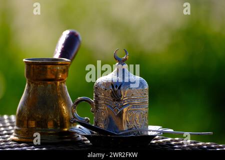 Türkischer Kaffee, arabischer Kaffee vor dem frischen grünen Hintergrund im silbernen Becher, Tasse Stockfoto