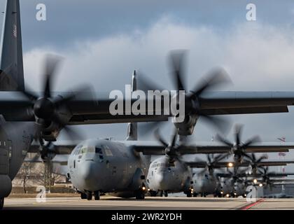 Sechs US Air Force C-130J Super Hercules vom 86. Airlift Wing Taxi die Fluglinie am Ramstein Air Base, Deutschland, 13. Februar 2024. Stockfoto