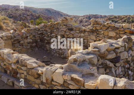 Alte Bunkhouse-Steinruinen in der Desert Queen Mine im Joshua Tree National Park, Kalifornien mit Blick auf die Berge Stockfoto