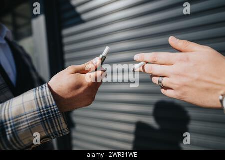 Geschäftspartner machen eine Pause im Freien mit einer Zigarette in der Stadt. Stockfoto