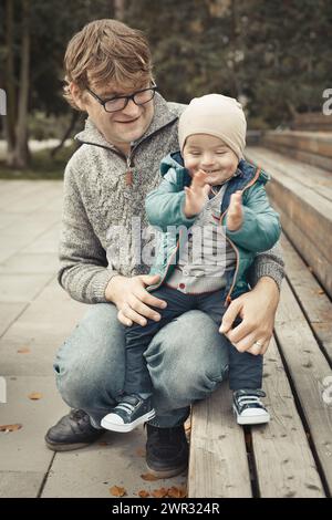 Vater und Sohn genießen den Tag im Herbstpark Stockfoto