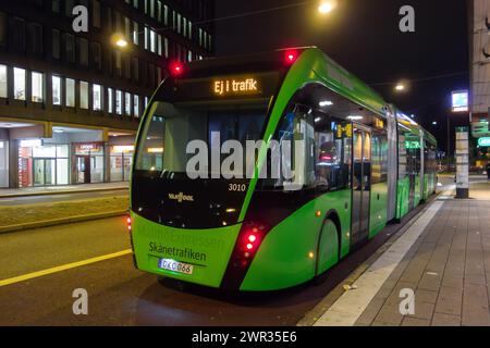 MALMÖ, SCHWEDEN - 26. OKTOBER 2014: VanHool ExquiCity 24 CNG Gelenkbus des öffentlichen Verkehrsunternehmens Skanetrafiken in Malmö bei Nacht Stockfoto