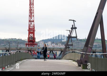 Menschen, die die Brücke über den Fluss Nervión überqueren, neben dem Guggenheim Museum in Bilbao-Baskenland-Spanien.13-3-2024 Stockfoto