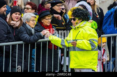 Das lokale Huber Baugeschäft läuft beim Bassersdorfer Fasnachtsumzug dabei. Eine Protagonistin verteilt Getränke. (Bassersdorf, Schweiz, 19.02.202 Stockfoto