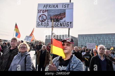 Ein Teilnehmer der Merkel muss weg-Demonstration trägt eine AFD-Mütze und hält ein Schild mit der Aufschrift „Afrika ist gross genug“. Stockfoto