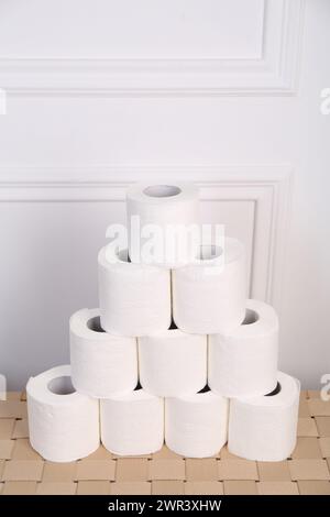 Pyramide von Toilettenpapierrollen auf dem Korbtisch Stockfoto