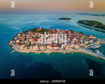 Primosten, Kroatien - aus der Vogelperspektive der Halbinsel Primosten, St.. Georges Kirche und Altstadt an einem sonnigen Sommermorgen in Dalmatien, Kroatien. Goldener Himmel, Stockfoto