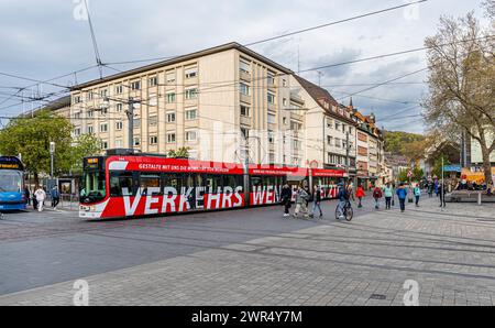 Eine Strassebahn der Linie 3 mit Zieldestionation Haid fährt am Platz der alten Synagoge vorbei. Auf der Seite steht der Schriftzug „Verkehrswende“. ( Stockfoto