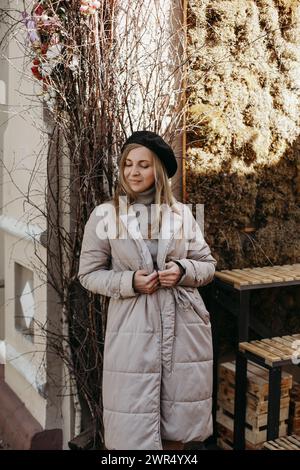 Eine Frau mit langen Haaren, die vor einem hohen Baum in einem Park steht. Vertikales Bild. Stockfoto