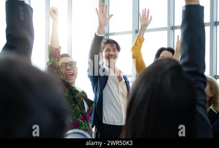Eine Gruppe von Menschen lächelt und winkt der Kamera zu. Die Szene ist glücklich und feierlich Stockfoto