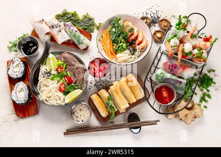 Verschiedene asiatische Gerichte, vietnamesische Gerichte. Pho bo, Nudeln, Frühlingsrollen, Saucen. Draufsicht. Stockfoto