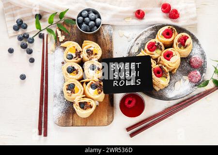 Asiatischer süßer Sushi-Pfannkuchen. Brötchen mit Frischkäse, Beeren und Früchten. Draufsicht Stockfoto