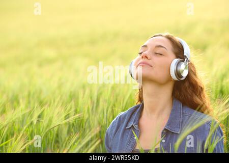 Frau, die Kopfhörer trägt, Meditation, Hörführung in der Natur Stockfoto