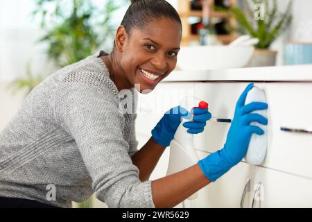 Schöne junge Frau auf einem Rollstuhl, die Hausarbeiten macht Stockfoto