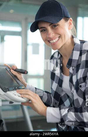 Glückliche Frau, die die Druckerwartung durchführt Stockfoto