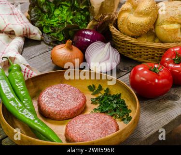 Hamburger in Vorbereitung, rustikale Szene zu Hause, Stillleben, Lebensmittelfotografie Stockfoto