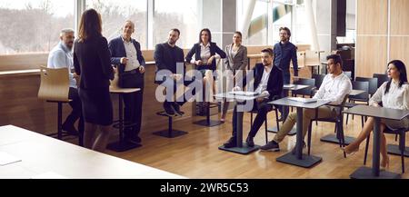 Professionelle Geschäftsfrau führt Schulungsseminare für verschiedene Geschäftsleute durch. Stockfoto