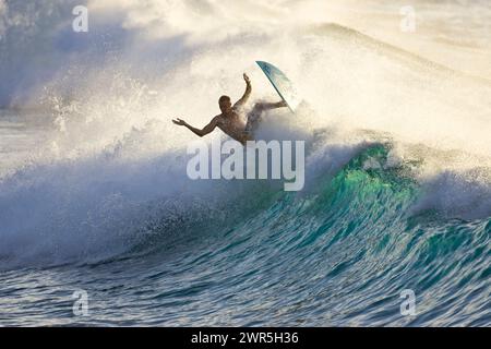 Ein junger Mann, der bei Rubber Duckies am Nordufer von Oahu surft Stockfoto
