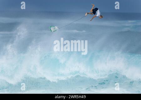 Ein junger Mann, der bei einem Surfwettbewerb am Nordufer von Oahu, Hawaii, ausgelöscht hat. Stockfoto