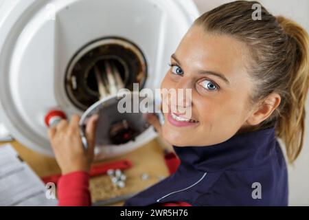 Weibliche auszubildende Klempner Arbeiten an zentralen Heizkessel Stockfoto