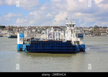 Die Torpoint-Fähren auf der Hamoaze mit Torpoint im Hintergrund. Ein umgelenkter Bus der Linie 10 befindet sich auf der Kreuzung wegen eines Unfalls auf der Saltash Rou Stockfoto