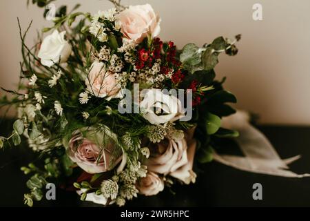 Modernes Bouquet mit Gänseblümchen, Rosen und Eukalyptus auf schwarzem Tisch Stockfoto