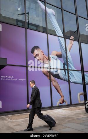 Wenige Monate vor den Olympischen Spielen 2024 in Paris haben Mitglieder der Öffentlichkeit am 7. März 2024 in London ein großes Bild von Max Whitlock, dem Turner des Teams GB und früheren Olympiasieger, vor der Coutts Bank on the Strand. Coutts Bank (und Natwest Bank) sind derzeit offizielle Unternehmenspartner von Team GB. Stockfoto