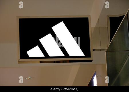 Adidas-Schild, Logo vor dem Adidas-Shop. Adidas ist ein weltweit tätiger Händler für Sportbekleidung und Laufschuhe. Stockfoto