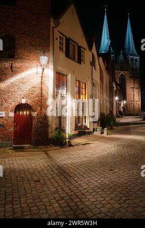 Malerische Stadt bei Nacht mit beleuchteten Straßen und monumentalen Gebäuden im niederländischen Dorf Deventer in den Niederlanden Stockfoto