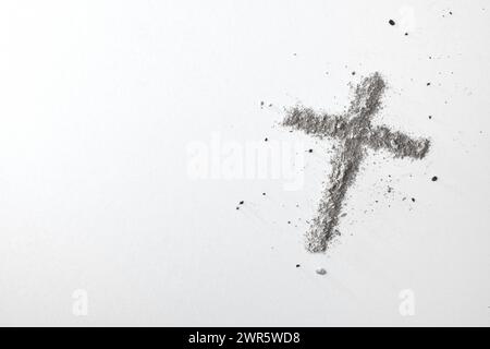 Christliches Kreuz mit Asche isoliert auf weißem Tisch. Draufsicht. Stockfoto