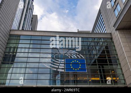 BRÜSSEL, BELGIEN, 23. Juni 2023: Blick auf ein modernes Gebäude mit der Flagge der Europäischen Union vor dem Hintergrund eines teilweise bewölkten Himmels. Flagge der Europäischen Union auf der Fassade des modernen Gebäudes. Hochwertige Fotos Stockfoto