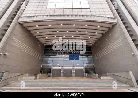 BRÜSSEL, BELGIEN, 23. Juni 2023: Symmetrische Vorderansicht des Altiero Spinelli-Gebäudeeingangs im Europäischen Parlament mit EU-Flagge und breiter Treppe. Großer Eingang zum Altiero Spinelli-Gebäude, EU-Parlament. Hochwertige Fotos Stockfoto