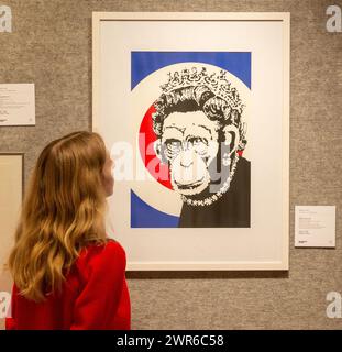 London, England, Großbritannien. März 2024. Mitarbeiter posiert mit Monkey Queen von Banksy (Foto: © Tayfun Salci/ZUMA Press Wire) NUR FÜR REDAKTIONELLE ZWECKE! Nicht für kommerzielle ZWECKE! Quelle: ZUMA Press, Inc./Alamy Live News Stockfoto