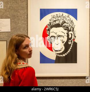 London, England, Großbritannien. März 2024. Mitarbeiter posiert mit Monkey Queen von Banksy (Foto: © Tayfun Salci/ZUMA Press Wire) NUR FÜR REDAKTIONELLE ZWECKE! Nicht für kommerzielle ZWECKE! Quelle: ZUMA Press, Inc./Alamy Live News Stockfoto