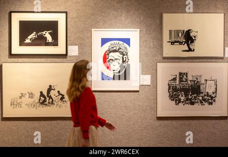 London, England, Großbritannien. März 2024. Mitarbeiter posiert mit Monkey Queen von Banksy (Foto: © Tayfun Salci/ZUMA Press Wire) NUR FÜR REDAKTIONELLE ZWECKE! Nicht für kommerzielle ZWECKE! Quelle: ZUMA Press, Inc./Alamy Live News Stockfoto