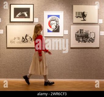 London, England, Großbritannien. März 2024. Mitarbeiter posiert mit Monkey Queen von Banksy (Foto: © Tayfun Salci/ZUMA Press Wire) NUR FÜR REDAKTIONELLE ZWECKE! Nicht für kommerzielle ZWECKE! Quelle: ZUMA Press, Inc./Alamy Live News Stockfoto