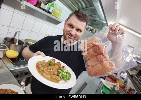 Tanne, Deutschland. März 2024. Küchenchef Timo Leisdorf bereitet im Restaurant Brockenbauer in Tanne frische Bullenhoden zu. Die neuartige Delikatesse wird bald auf der Speisekarte des Restaurants stehen. Brockenbauer Thielecke in Tanne vermarktet fast hundert Prozent seiner Rinder. Mit den Bullenhoden haben sie eine ungewöhnliche Spezialität geschaffen, die als Bergaustern serviert werden soll. Quelle: Matthias Bein/dpa/Alamy Live News Stockfoto