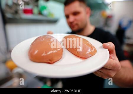 Tanne, Deutschland. März 2024. Küchenchef Timo Leisdorf bereitet im Restaurant Brockenbauer in Tanne frische Bullenhoden zu. Die neuartige Delikatesse wird bald auf der Speisekarte des Restaurants stehen. Brockenbauer Thielecke in Tanne vermarktet fast hundert Prozent seiner Rinder. Mit den Bullenhoden haben sie eine ungewöhnliche Spezialität geschaffen, die als Bergaustern serviert werden soll. Quelle: Matthias Bein/dpa/Alamy Live News Stockfoto