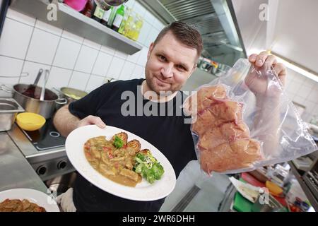 Tanne, Deutschland. März 2024. Küchenchef Timo Leisdorf bereitet im Restaurant Brockenbauer in Tanne frische Bullenhoden zu. Die neuartige Delikatesse wird bald auf der Speisekarte des Restaurants stehen. Brockenbauer Thielecke in Tanne vermarktet fast hundert Prozent seiner Rinder. Mit den Bullenhoden haben sie eine ungewöhnliche Spezialität geschaffen, die als Bergaustern serviert werden soll. Quelle: Matthias Bein/dpa/Alamy Live News Stockfoto